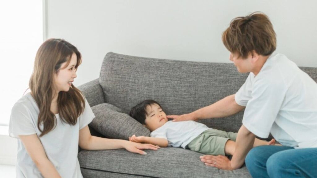 子供を寝かしつけ笑顔の夫婦