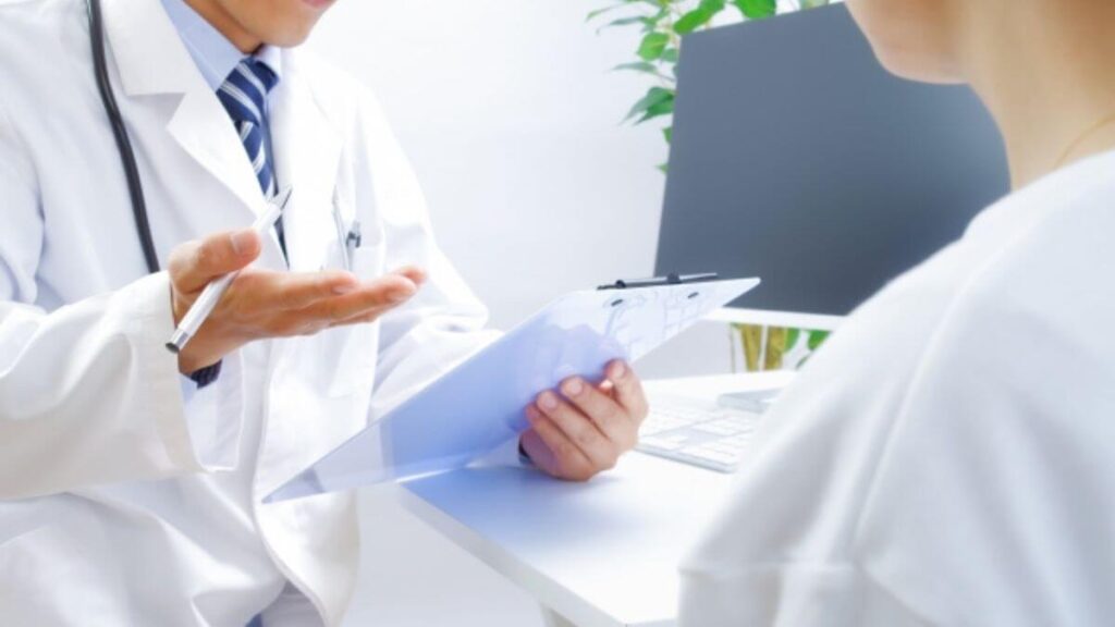 白衣の男性からカウンセリングを受ける女性