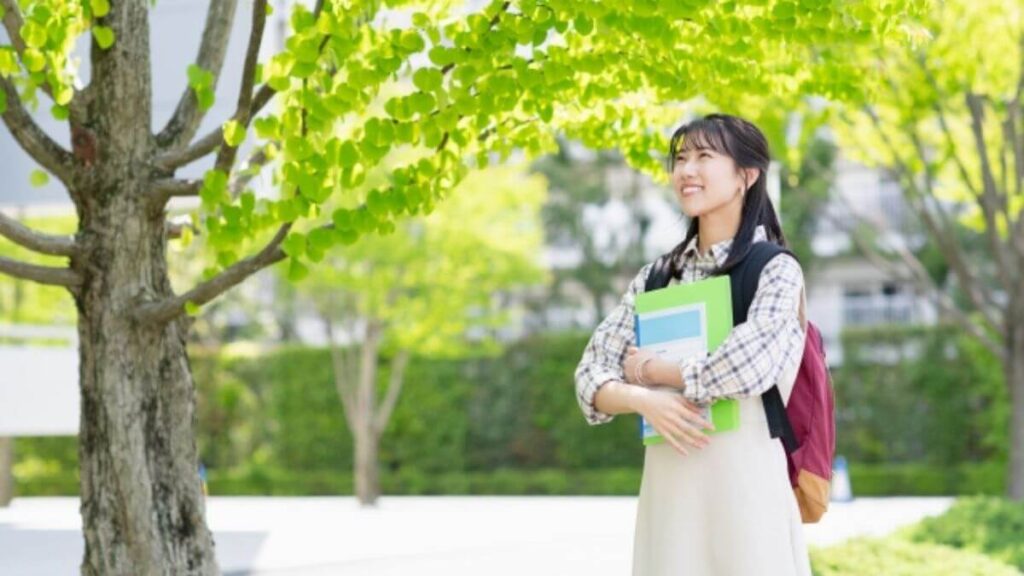 木の下でリラックスした表情をする若い女性