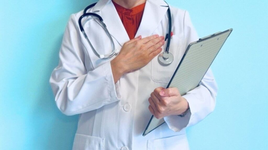 胸に手を置き安心させる白衣姿の女性