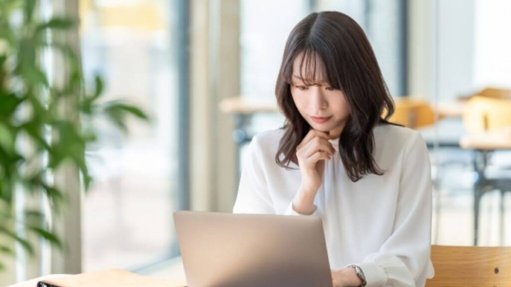 パソコンに向い話すことをまとめる若い女性