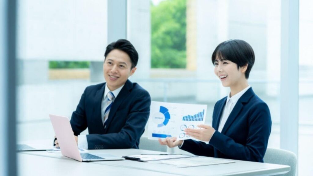 笑顔でお客さんと話す営業職の男女2人