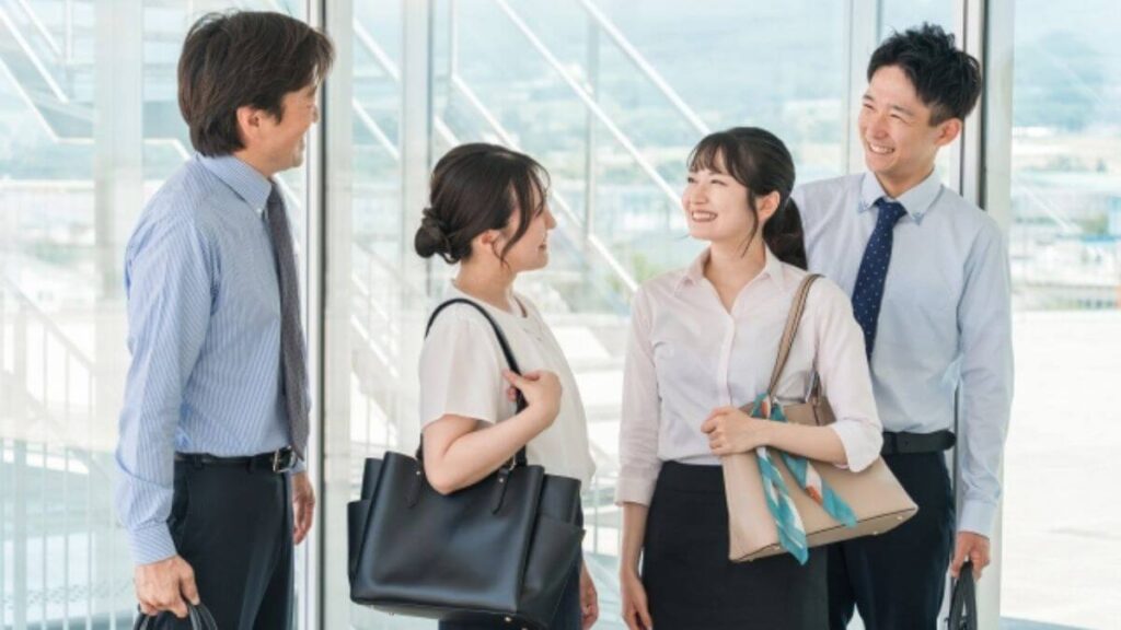 スーツ姿の男女4人が仲良く談笑する様子