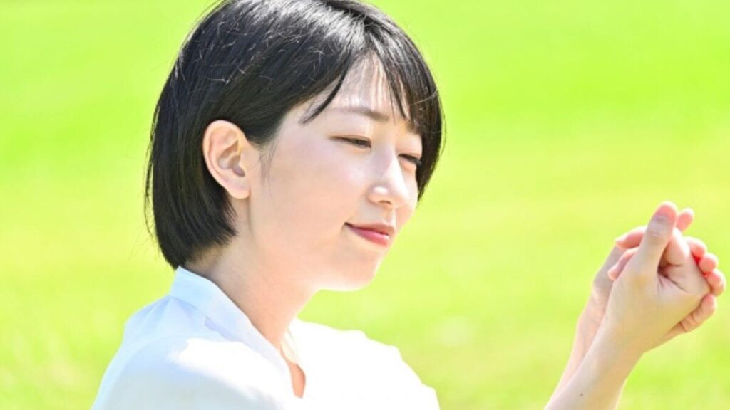 晴天の外で日光浴をする若い女性