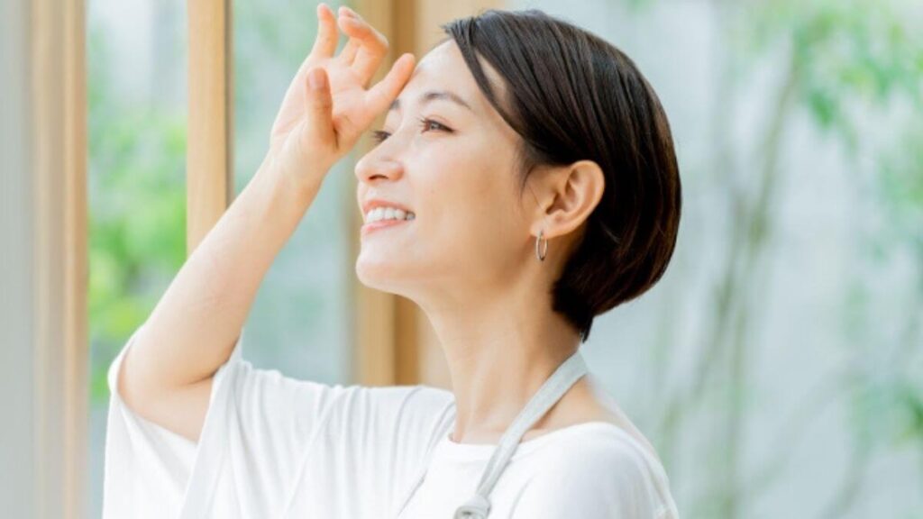 爽やかな笑顔で外を見る女性