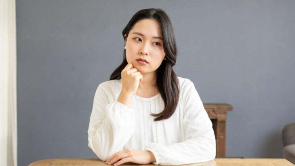 部屋で疑問を感じる主婦の女性