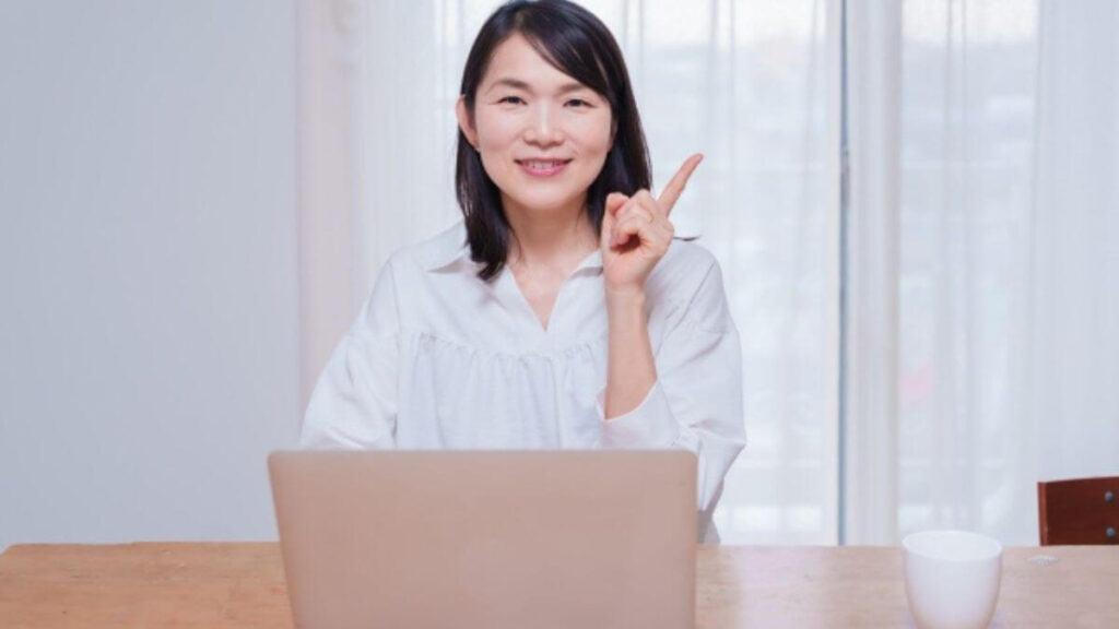 人差し指をあげ説明する主婦