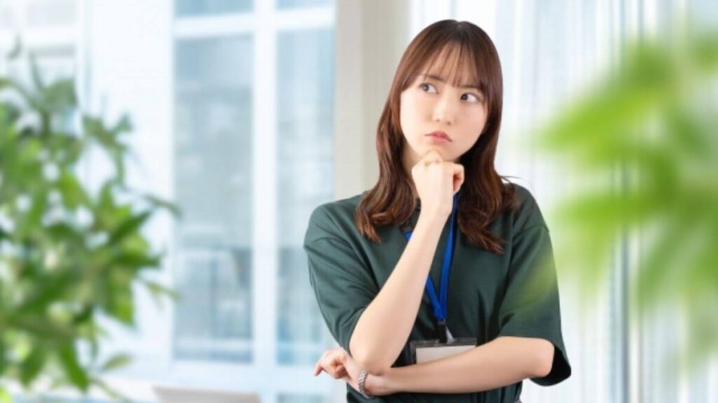 あごに手を当て疑問を感じる若い女性