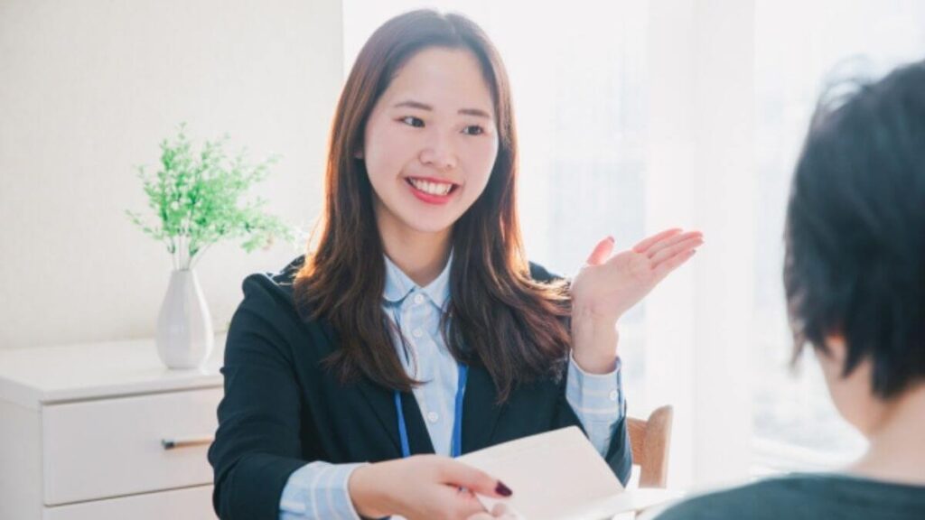 相談者に笑顔で説明をするスーツ姿の若い女性