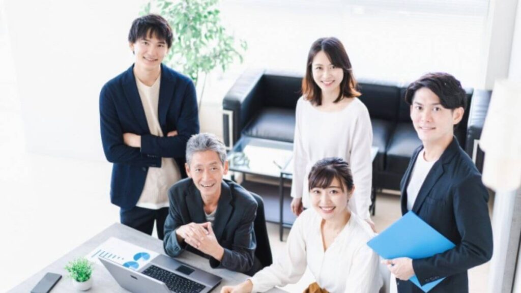 会社の従業員が笑顔で集まる様子