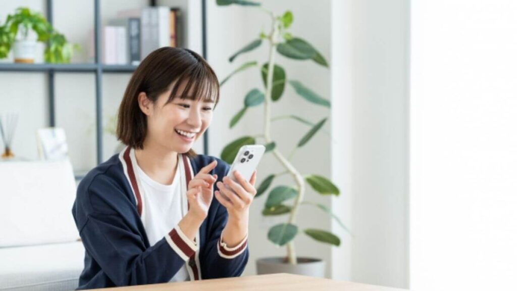 笑顔でスマートフォンを使う若い女性