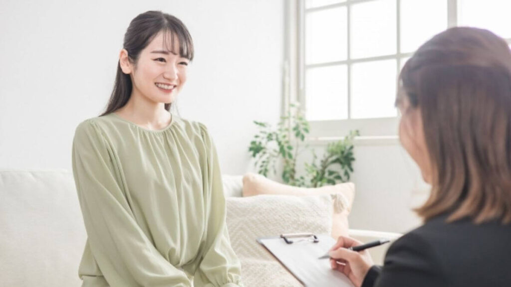 カウンセラーに相談する笑顔の若い女性