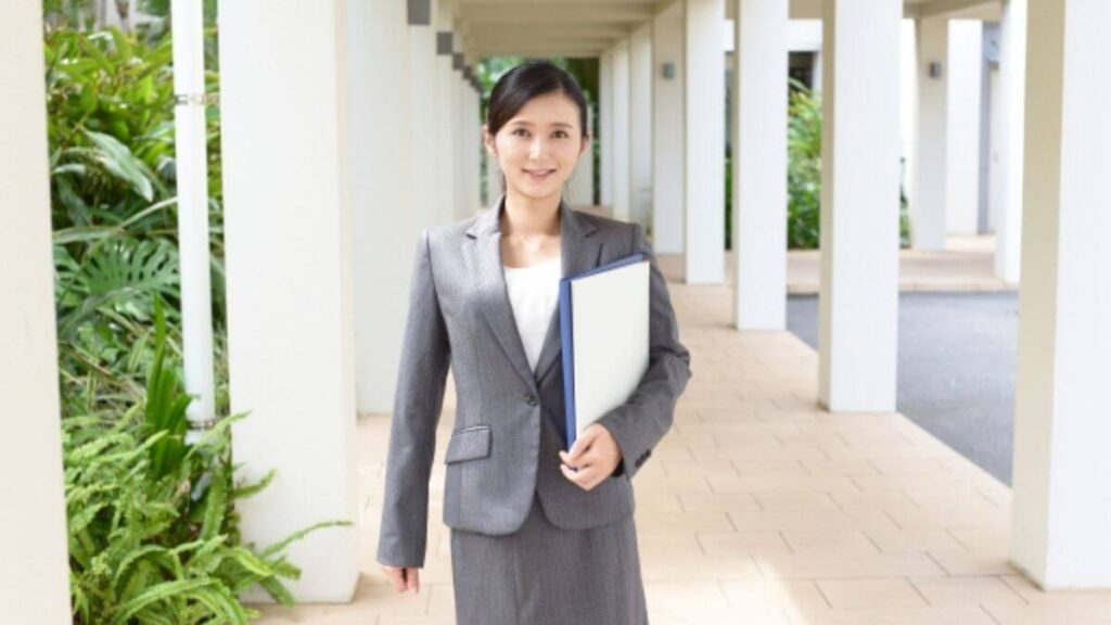 笑顔で廊下を歩くスーツ姿の女性カウンセラー