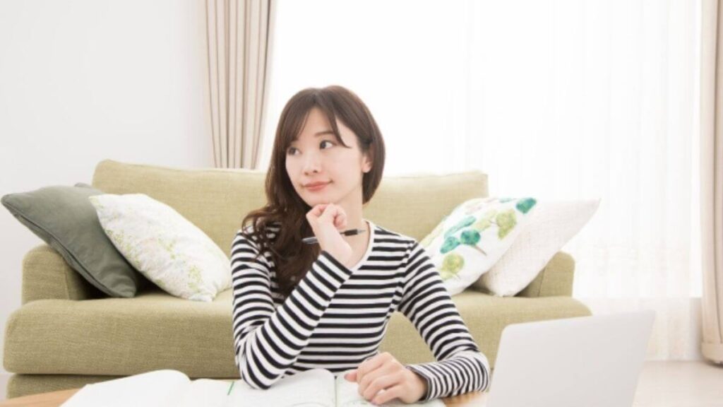 自宅でパソコンを使い勉強をする若い女性