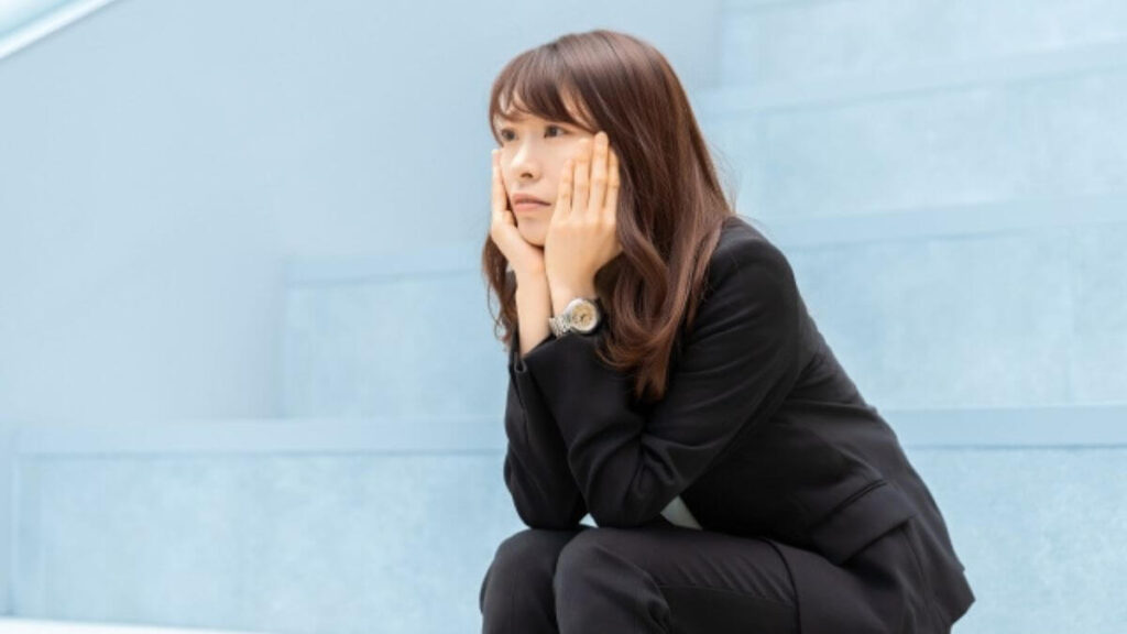 階段で不安を感じるスーツ姿の若い女性