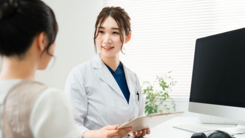 相談者の話に耳を傾ける白衣の女性心理カウンセラー