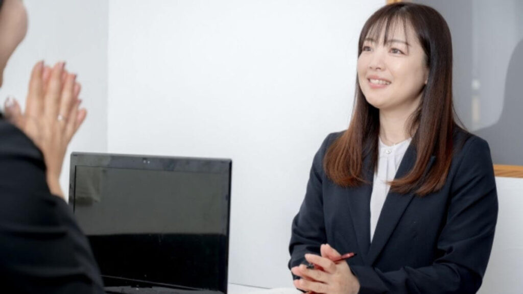 相談者の話を笑顔で聞く女性の心理カウンセラー