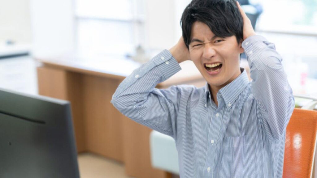 手を頭につけ後悔するシャツ姿の若い男性