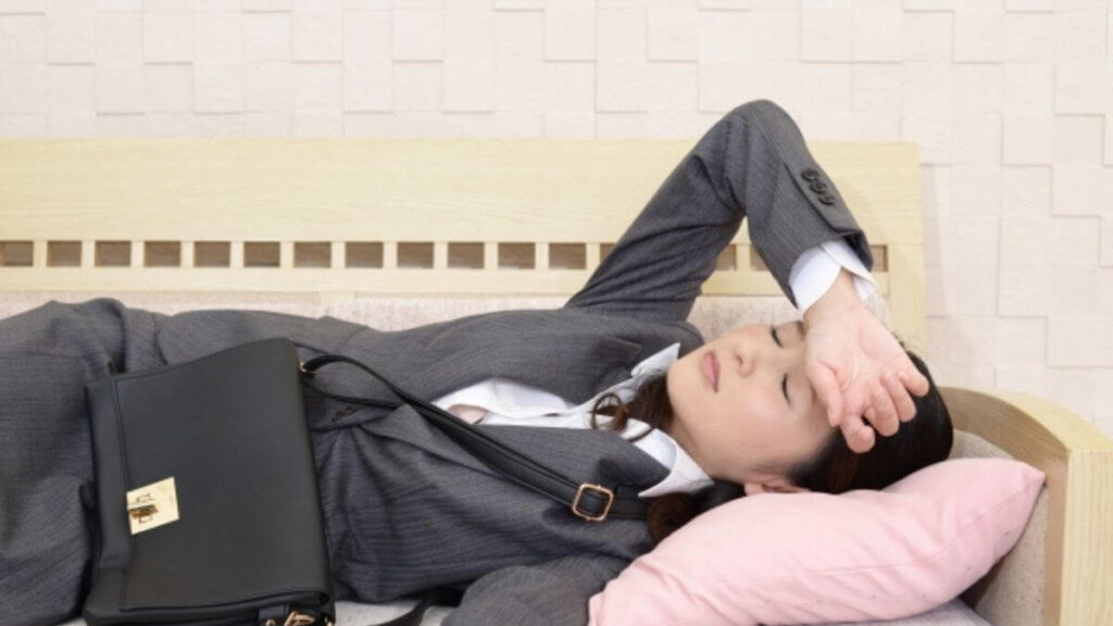 疲れ果てソファーで寝るスーツ姿のカウンセラーの女性