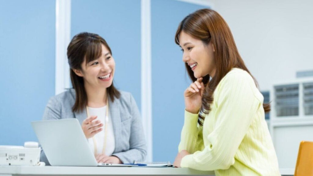 相談者の話を笑顔で聞くスーツ姿の若い女性