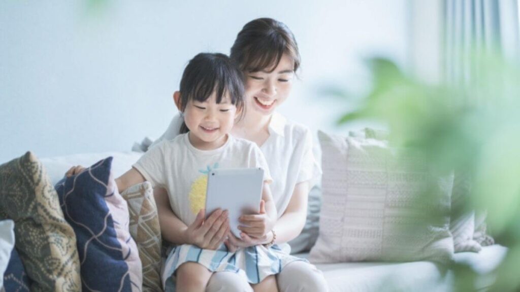 自宅で子供とタブレットを使う若い母親