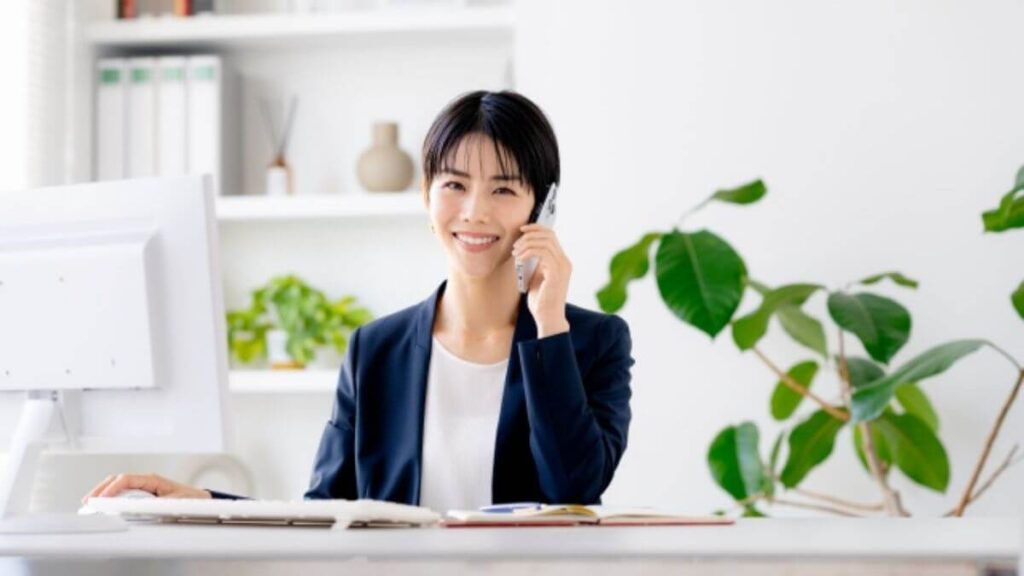 笑顔で電話をするスーツ姿の若い女性