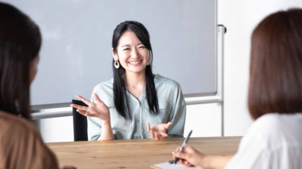 同僚を笑顔で会話をする若い女性