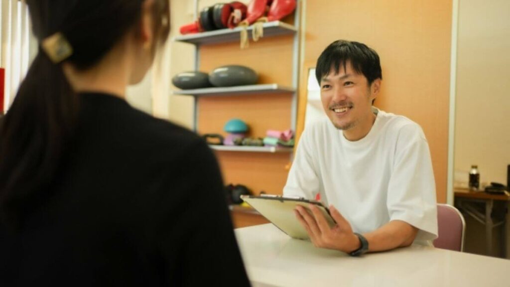 女性の悩みを笑顔で聞くカウンセラーの男性