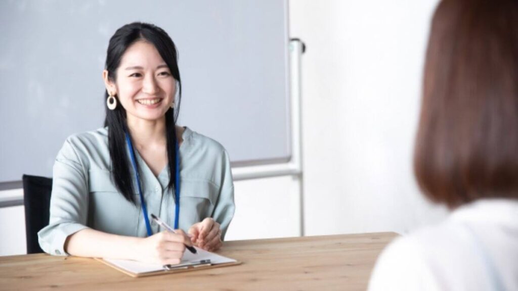 同僚の話を聞く若い女性のカウンセラー