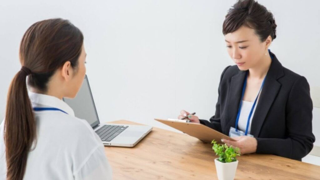 相談者の話をメモするスーツ姿の女性