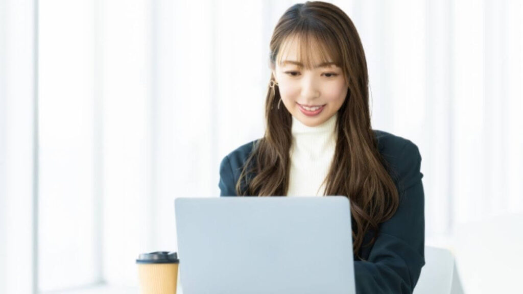 リラックスした表情でパソコン作業をするスーツ姿の女性