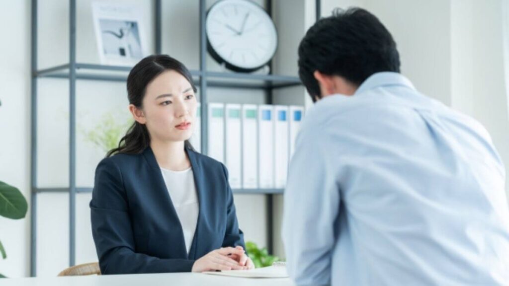 男性相談者の話を深刻そうに聞くカウンセラーの女性