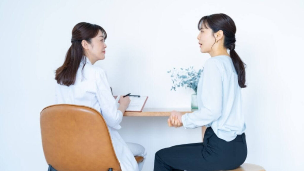 医師の診察を受ける若い女性