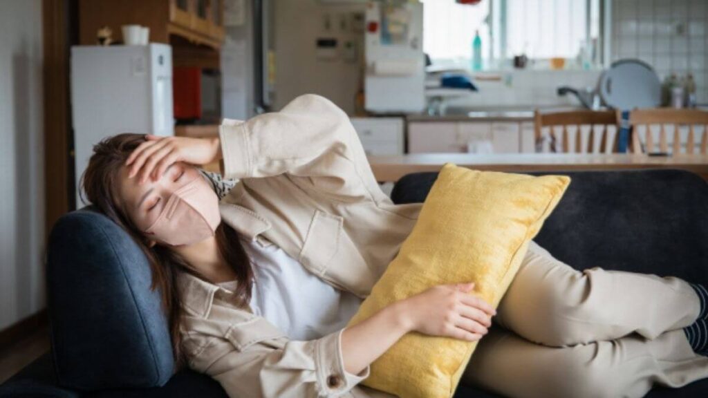 頭に手を置き横たわる若い女性