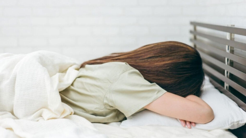 ベッドの中で落ち込み起きられない若い女性