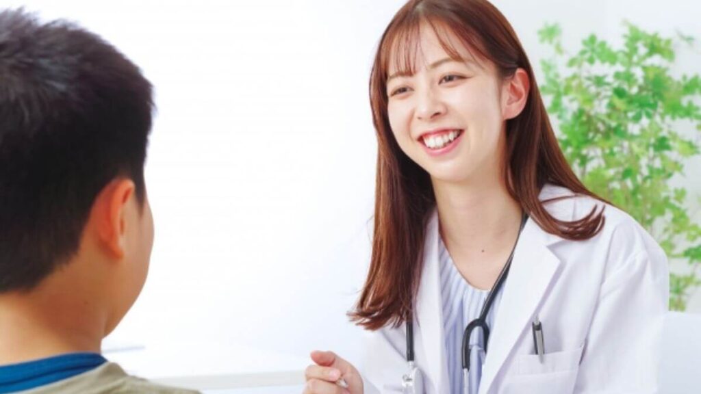 子供と笑顔で会話する白衣姿の若い女性