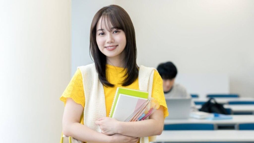 教科書とノートを持ち笑顔の若い女性