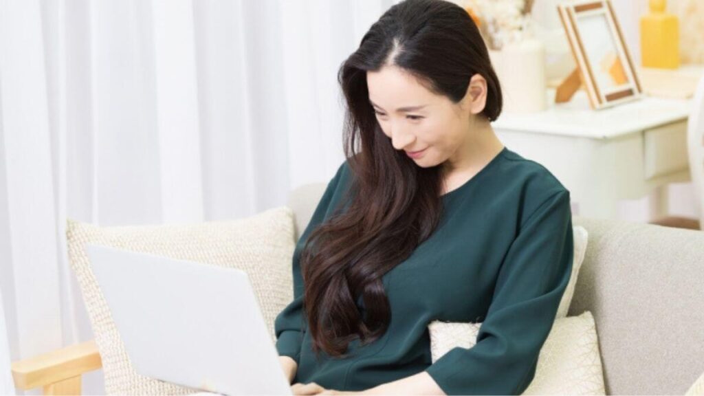 笑顔でパソコン作業をするミドルの女性