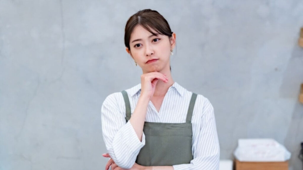 深刻な顔で考える若い女性