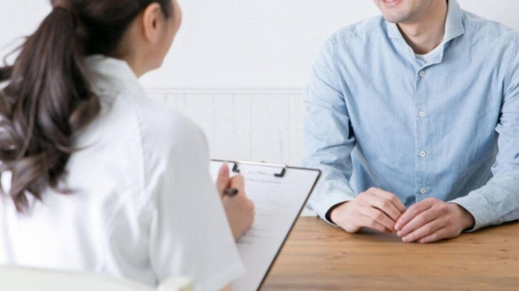 男性相談者の話を聞く女性カウンセラー