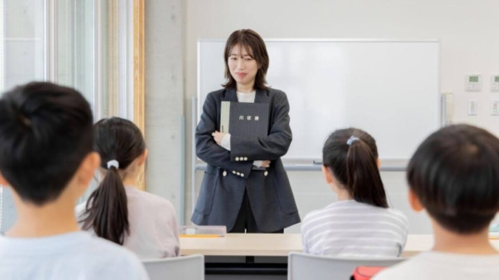 子供達の前で優しく話すスーツ姿の女性