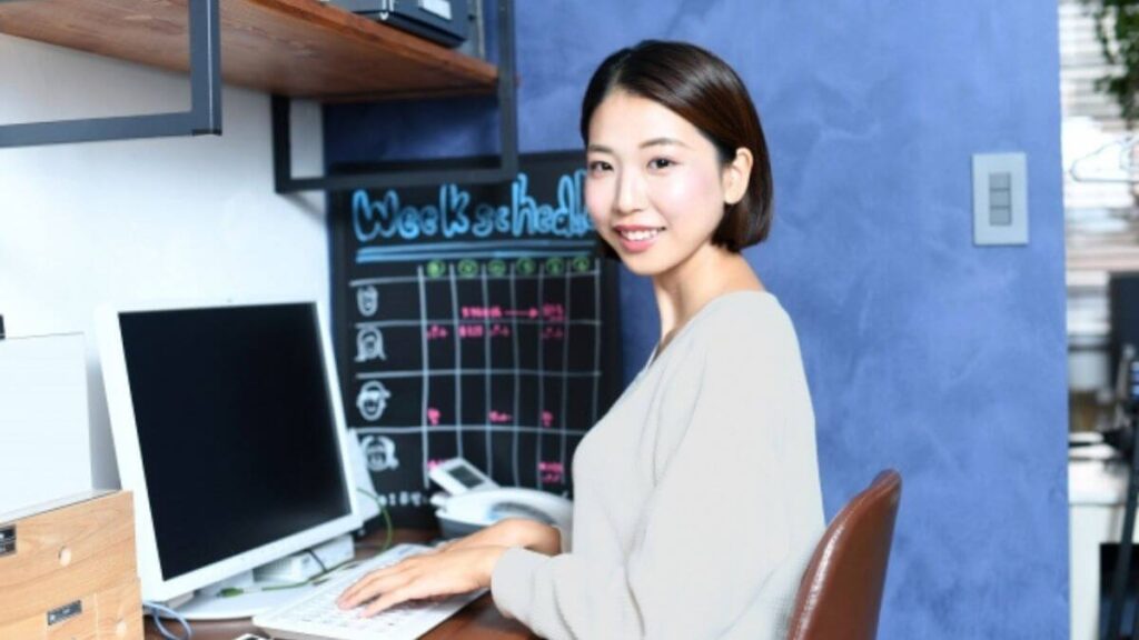 学校内でパソコン作業をするカウンセラー