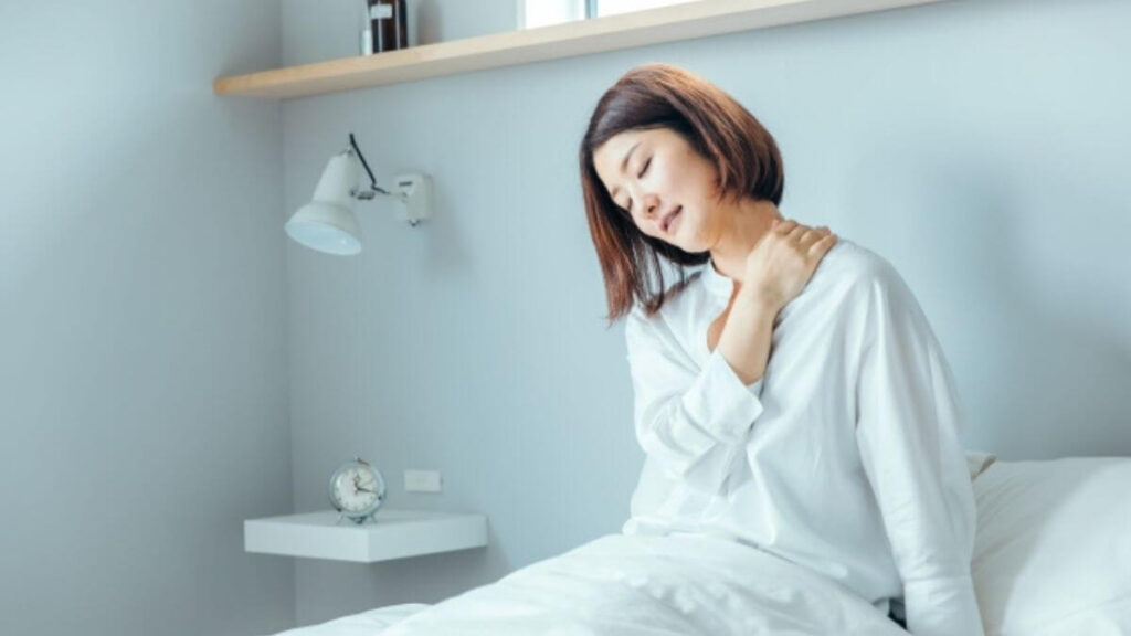 肩に手を置き疲れた表情のミドルの女性