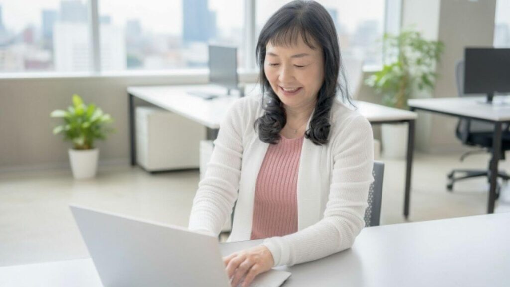 笑顔でパソコン作業をするミドルの女性