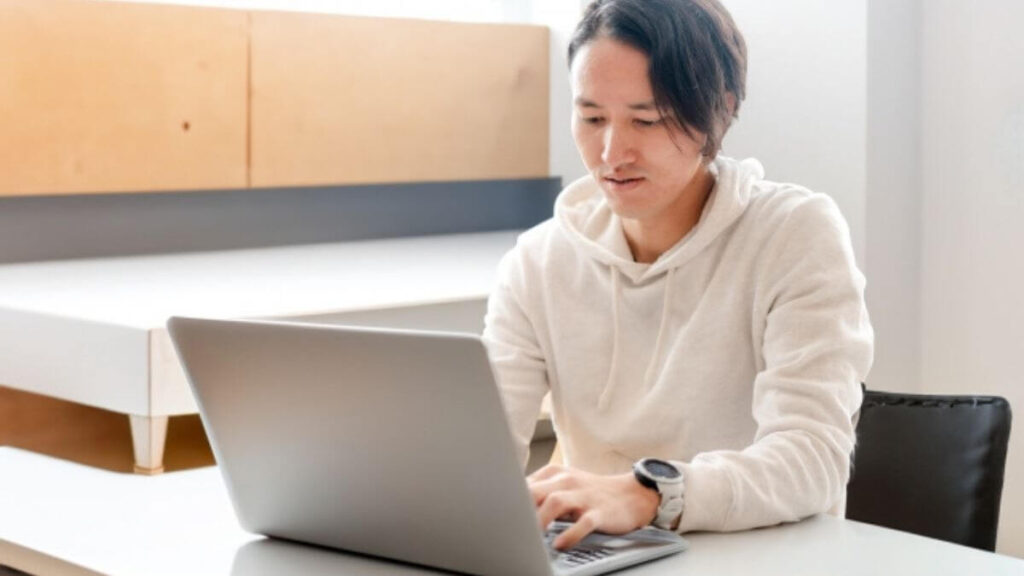 室内でパソコン作業をする若い男性