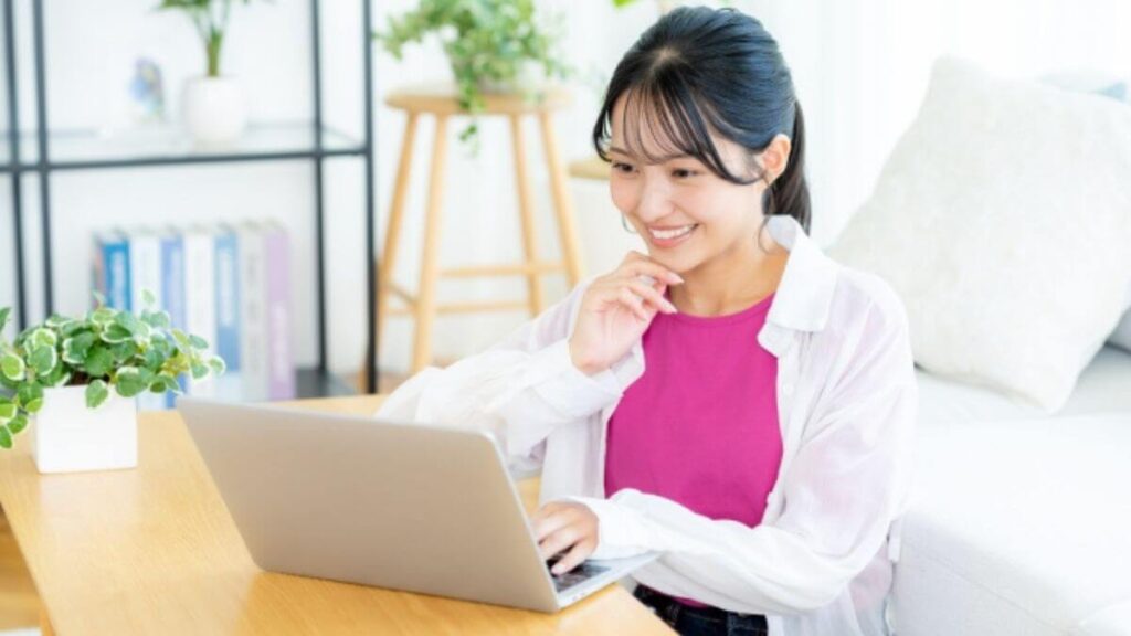 パソコンを使い笑顔で勉強する若い女性