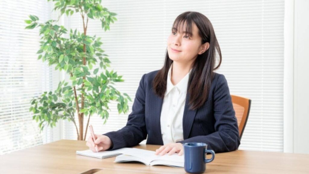 思い出しながらメモに書いていくスーツ姿の女性