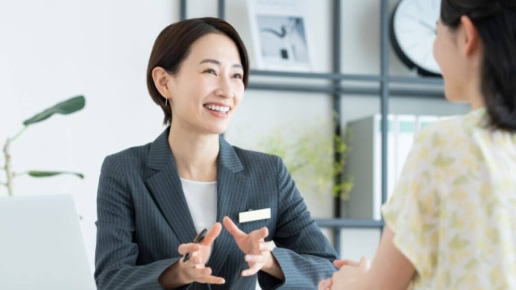 相談者に笑顔で話をするスーツ姿の女性