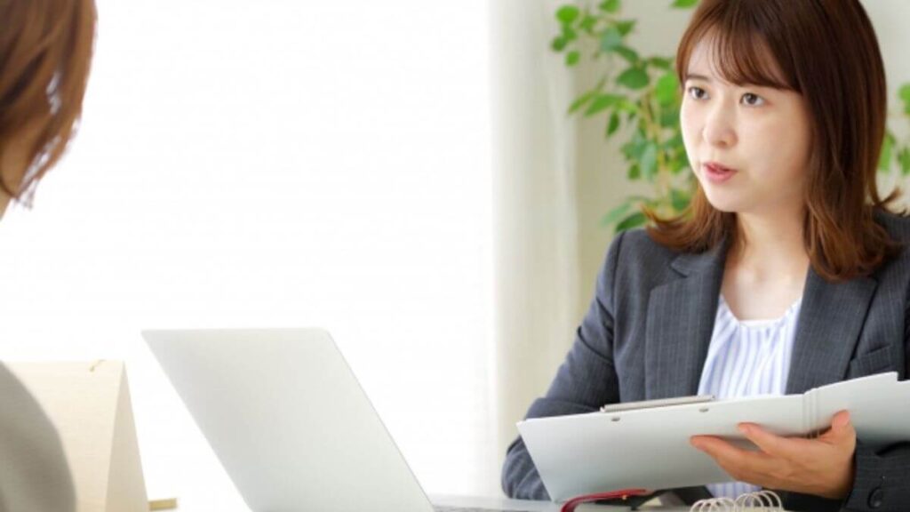スーツ姿で相談者の話を聞く若い女性