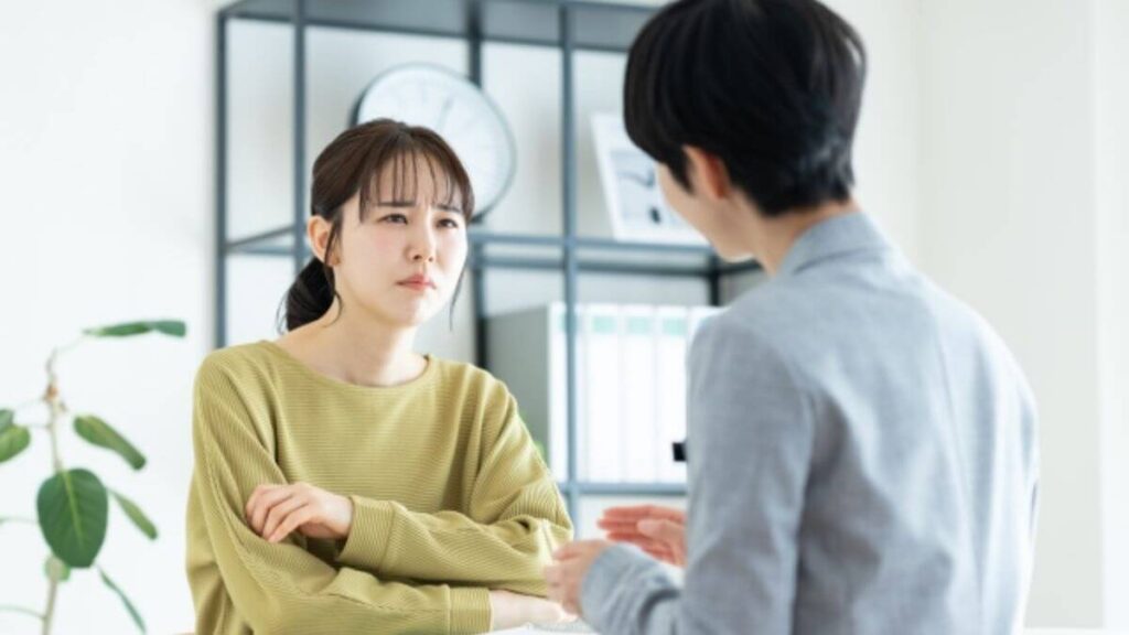 つらい顔をしてカウンセリングを受ける若い女性